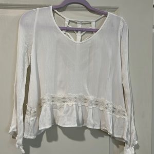 White blouse with slight bell sleeves. Cutout back